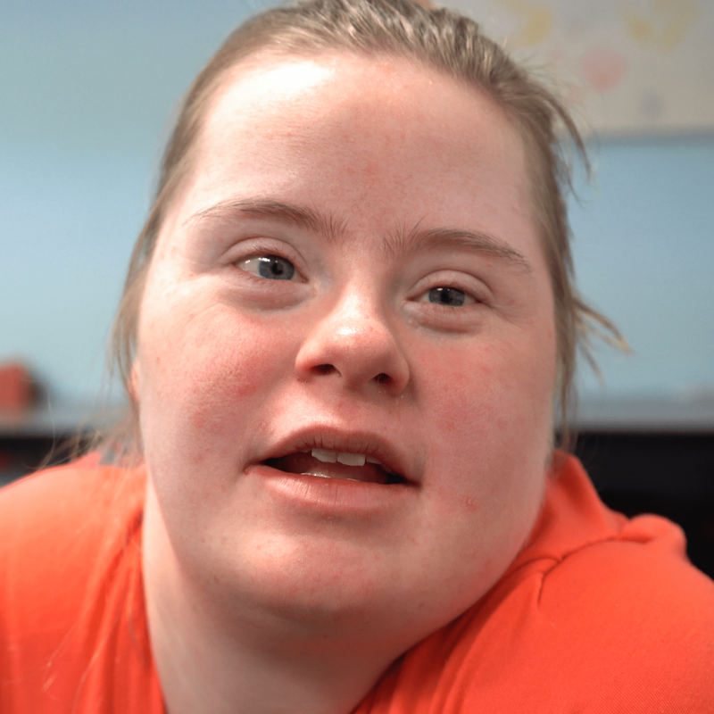 Emily Felter (young woman with Down syndrome) smiles at the camera